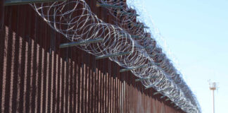 Border fence topped with coils of razor wire