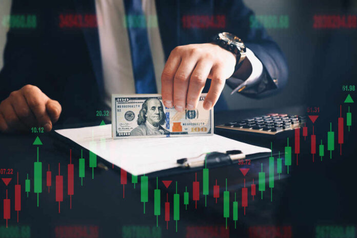 Businessman,Holding,Bunch,Of,Dollars.,Financial,Investment,Concept.,Forex,Trading Businessperson holding a hundred-dollar bill over documents with stock chart overlay
