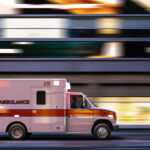 Ambulance driving through city street at speed
