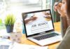 Person at desk viewing job search page on laptop