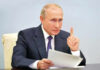 Putin Meeting Ends Standoff Vladimir Putin, holding papers, in a meeting.