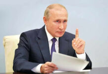 Putin Meeting Ends Standoff Vladimir Putin, holding papers, in a meeting.