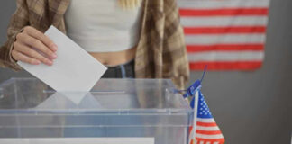 Person casting vote into a ballot box.