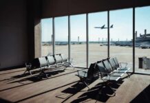 DFW Crowned Most Stressful – Here’s Why View of an airport waiting area with an airplane taking off in the background