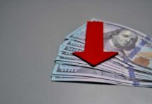 Protest Café Drowns In Debt Red downward arrow on stack of US hundred-dollar bills