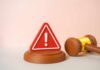 Diner Claims Tooth – Vendor Scramble Begins A red warning sign next to a legal gavel on a light background