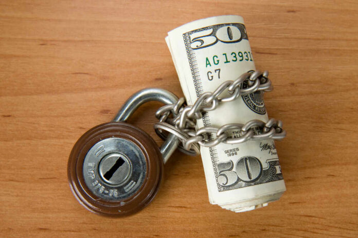 Locked,Money,With,Padlock Rolled US dollars wrapped in chain with a padlock