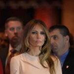 Melania Trump at an event with a crowd in the background