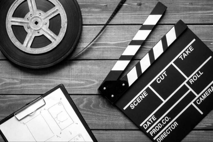 shutterstock_539523673-modified Film reel, storyboard, and clapperboard on wooden surface.