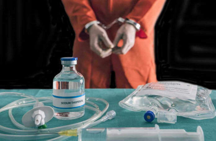 shutterstock_762356716 Handcuffed person in orange suit with lethal injection supplies.